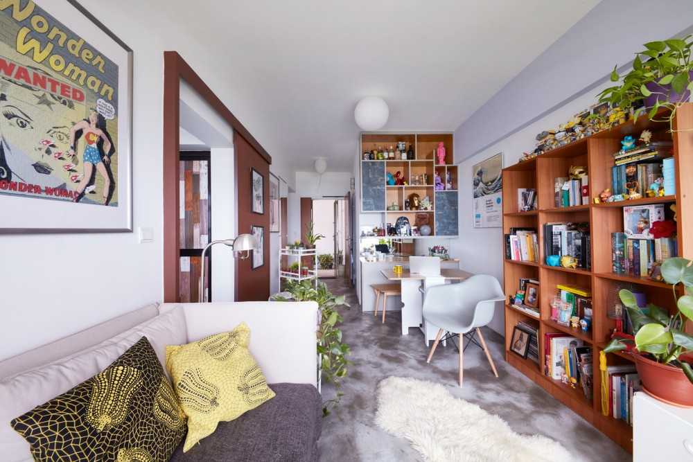 eclectic living room with bookshelf and cement floor